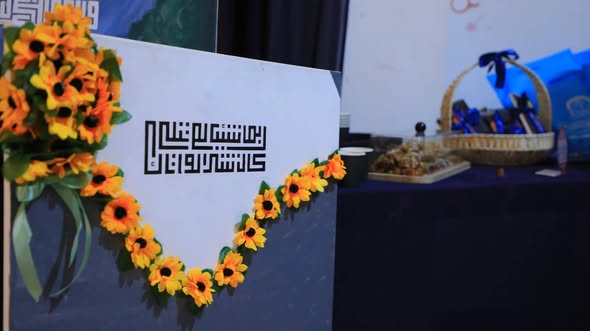 صورة للوحة فنية للخط الكوفي الهندسي مزينة بورود عباد الشمس