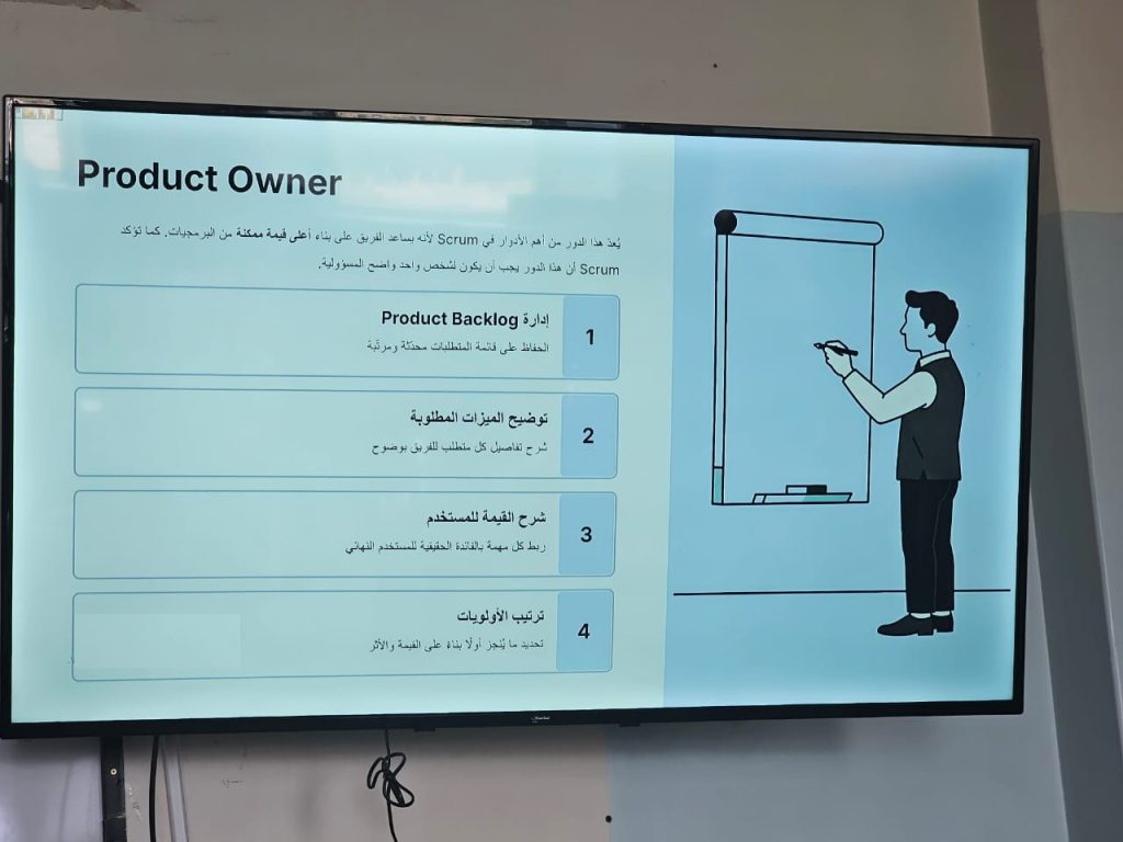 شريحة عرض تقديمي تتضمن رسمًا توضيحيًا لرجل يرتدي زيًا مهنيًا ويحمل قلمًا بجانب لوحة كتابة، مع قائمة مرقمة (1-4) من المسؤوليات الرئيسية لدور Product Owner باللغة العربية: إدارة Product Backlog، توضيح الميزات المطلوبة، شرح القيمة للمستخدم، وترتيب الأولويات.